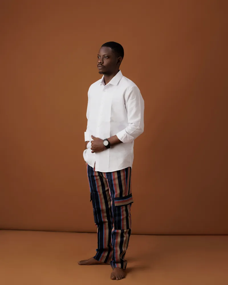 Mayowa in a white shirt and woven trousers